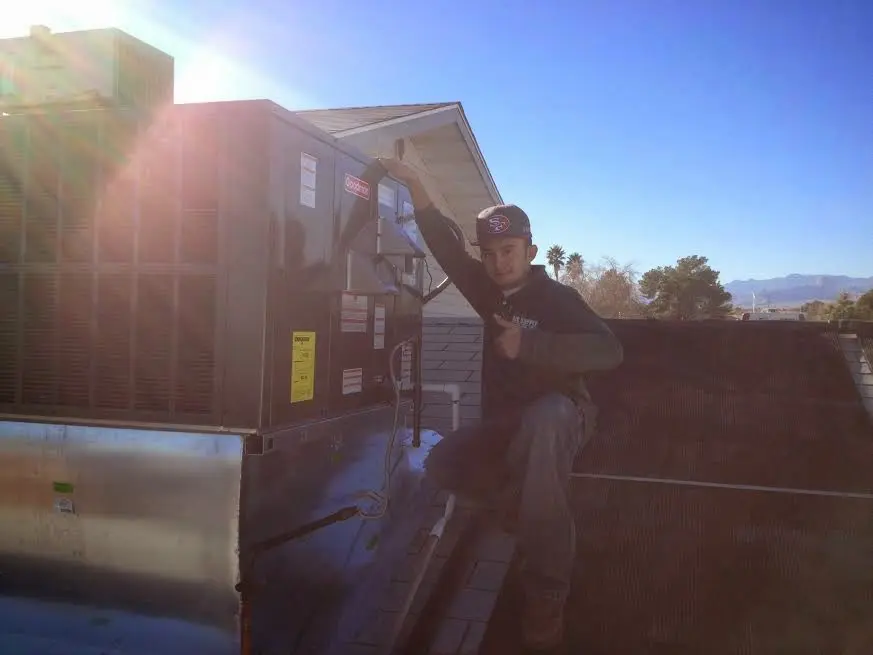 HVAC technician performing AC Tune-Up on a rooftop unit in Pikeville